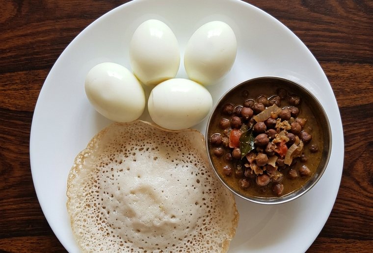 An AI-drawn plate of appam, kadala curry and boiled eggs
